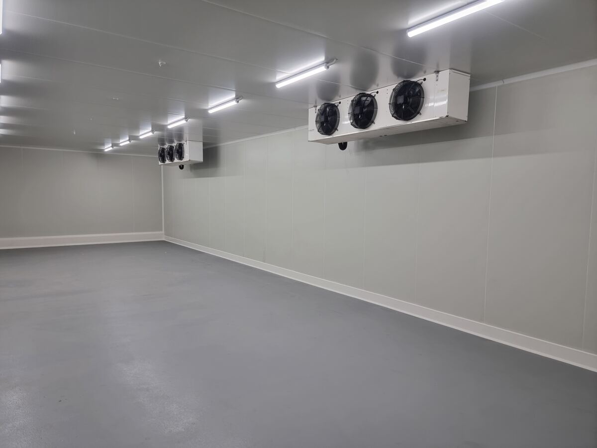 Cold storage facility corridor with numbered bay doors and ceiling evaporators