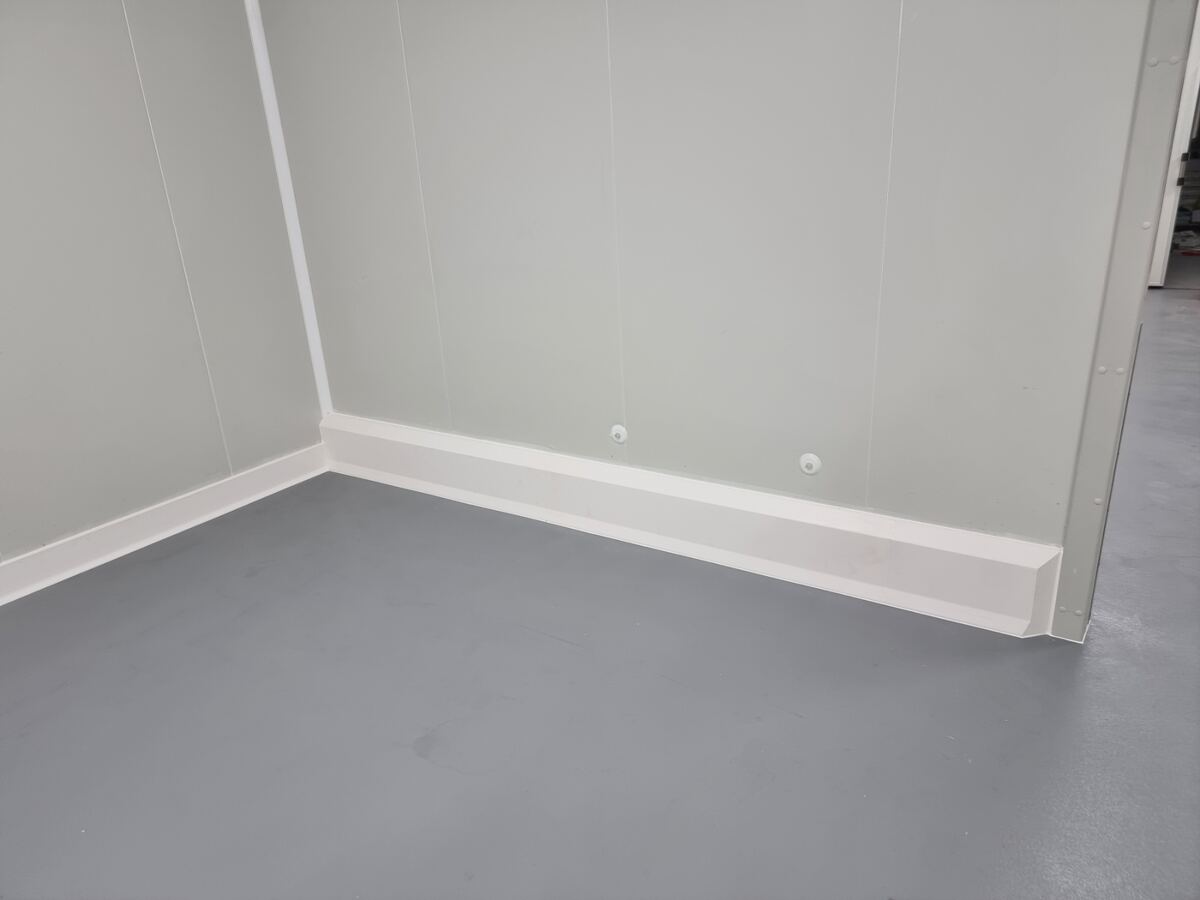 Close up of insulated panel wall corner with hygienic skirting detail